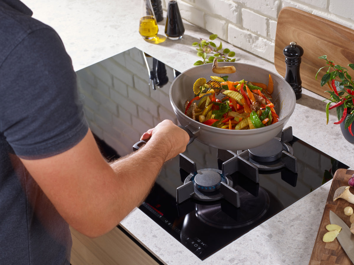 Cook a colorful wok dish in the Fissler Ceratal® Wok - durable, PTFE-free German quality with fresh herbs and spices at hand.