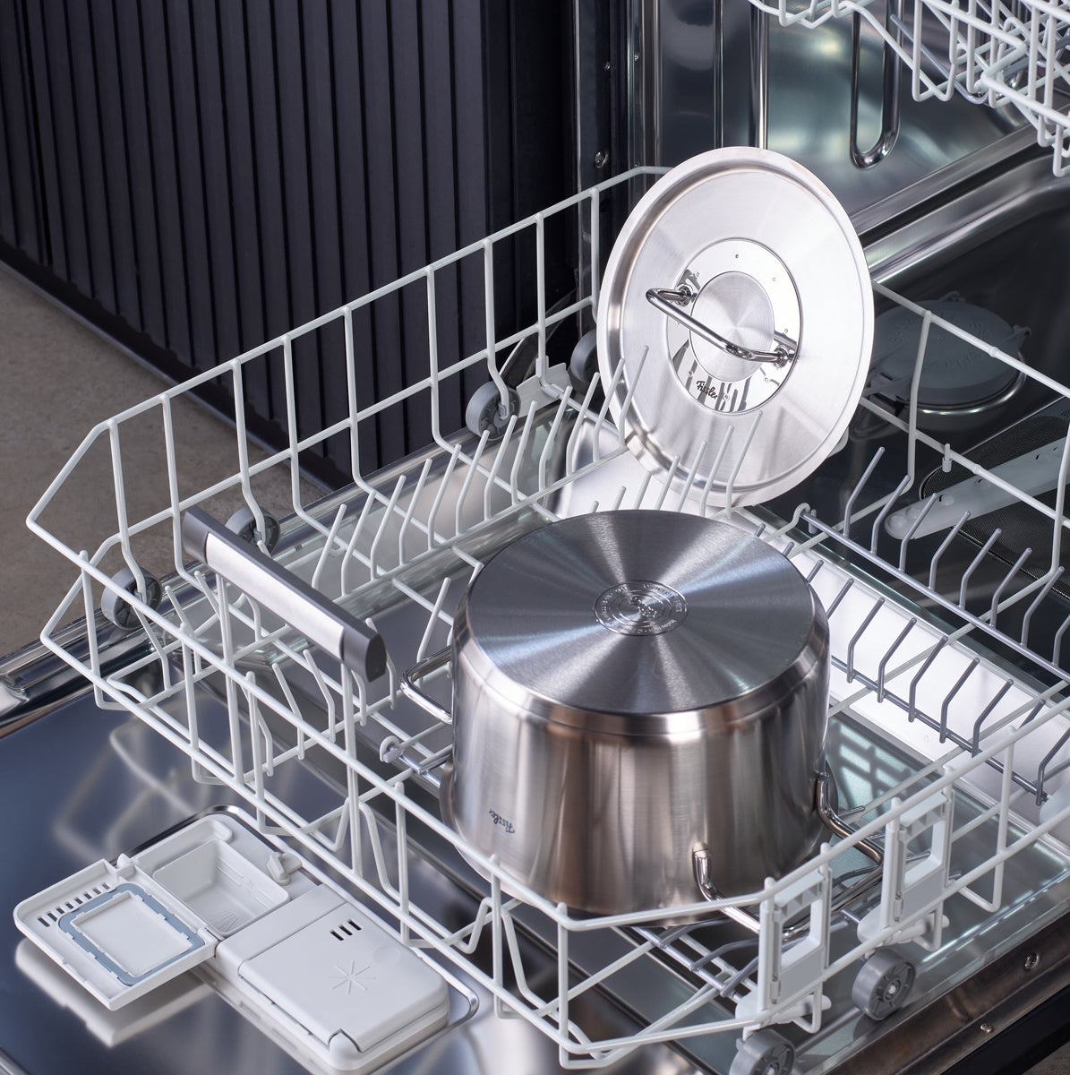 The Fissler Pure Collection® Cookware Set made of recycled stainless steel in the lower rack of an open dishwasher.